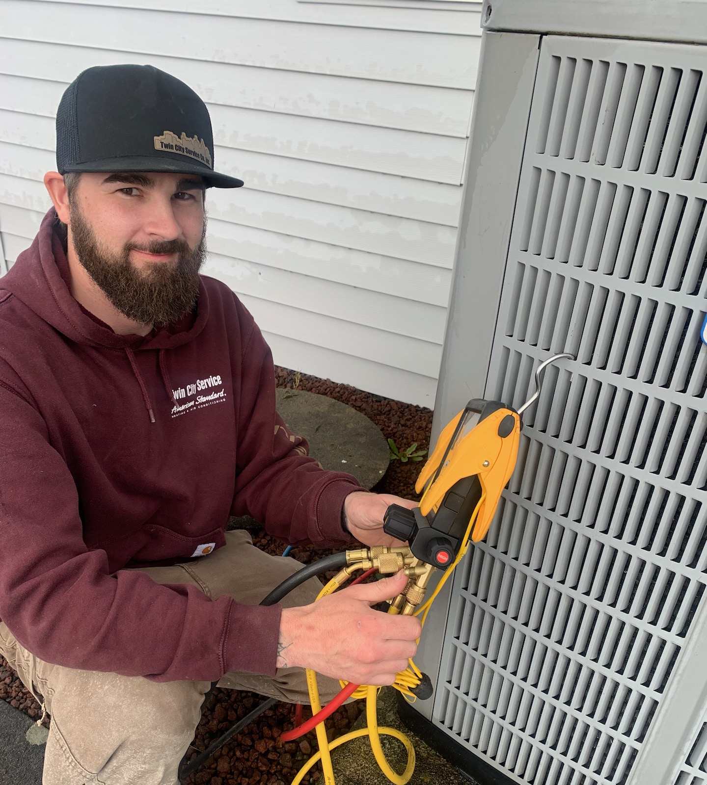 Twin City Service technician servicing a residential air conditioning unit
